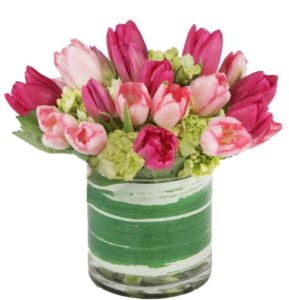 Assorted pink tulips in a leaf-lined cylinder vase with mini green hydrangea will bring a breath of Spring for your sweetheart! 