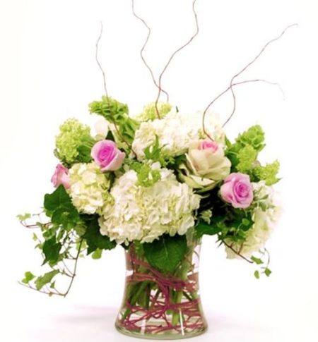 A gorgeous spring garden mix! Featuring beautiful pink roses, white hydrangea, and green accents such as bells of Ireland, this arrangement is sure to stun and delight!